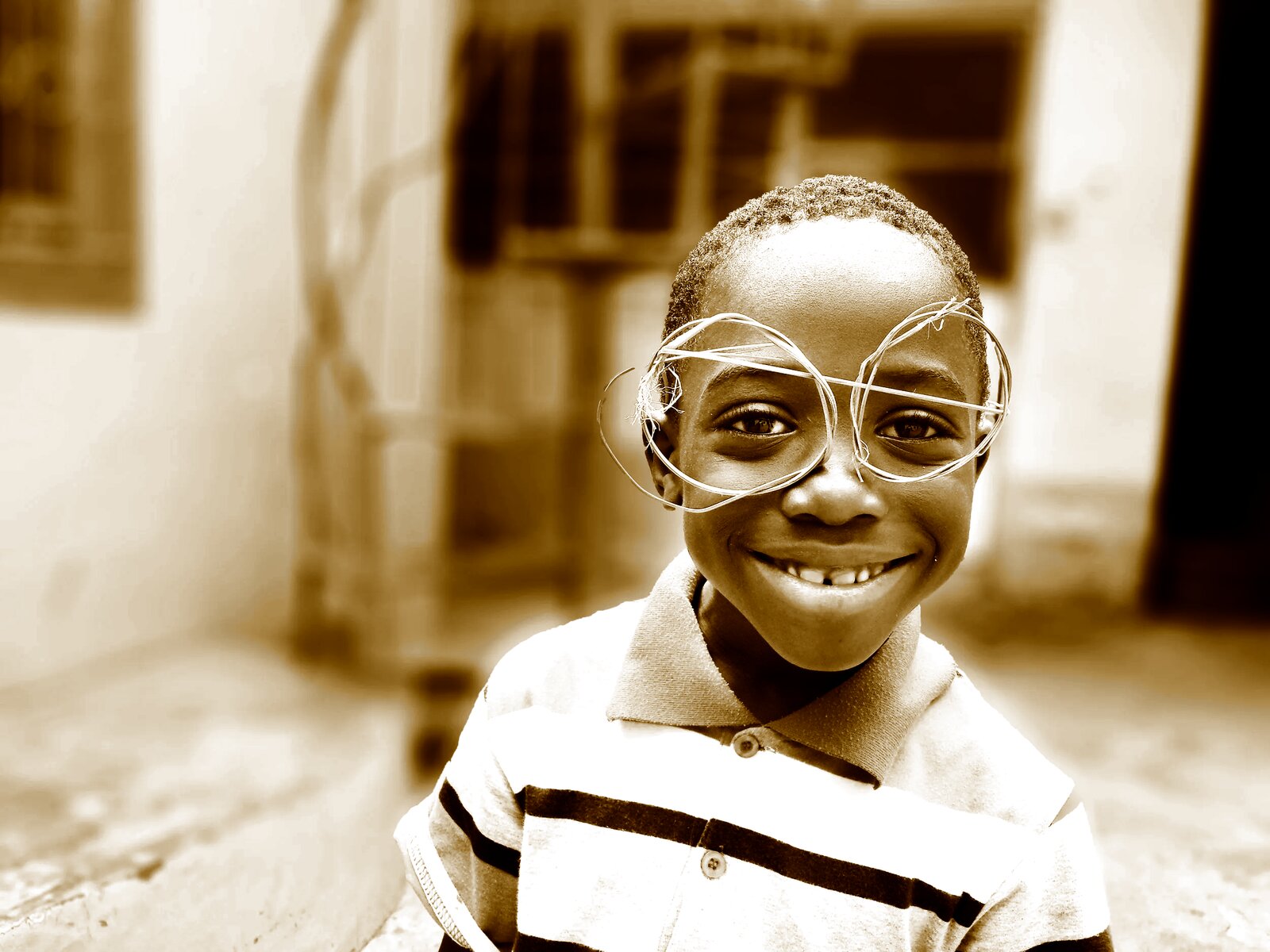 A Norman Manley High School student wearing eyeglasses he built himself from wire — determined to see and to learn